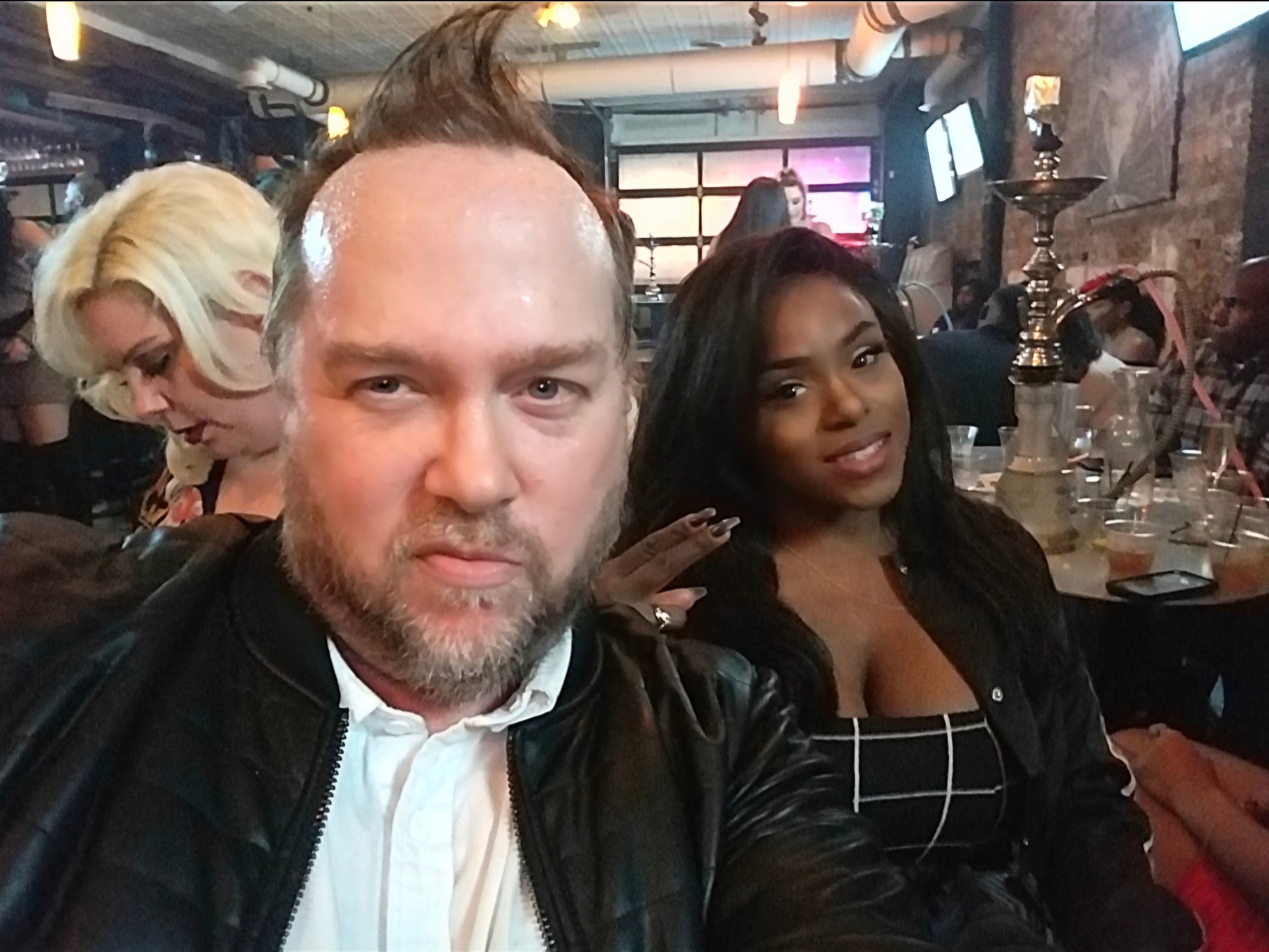 Kene Bell with a friend in a busy restaurant