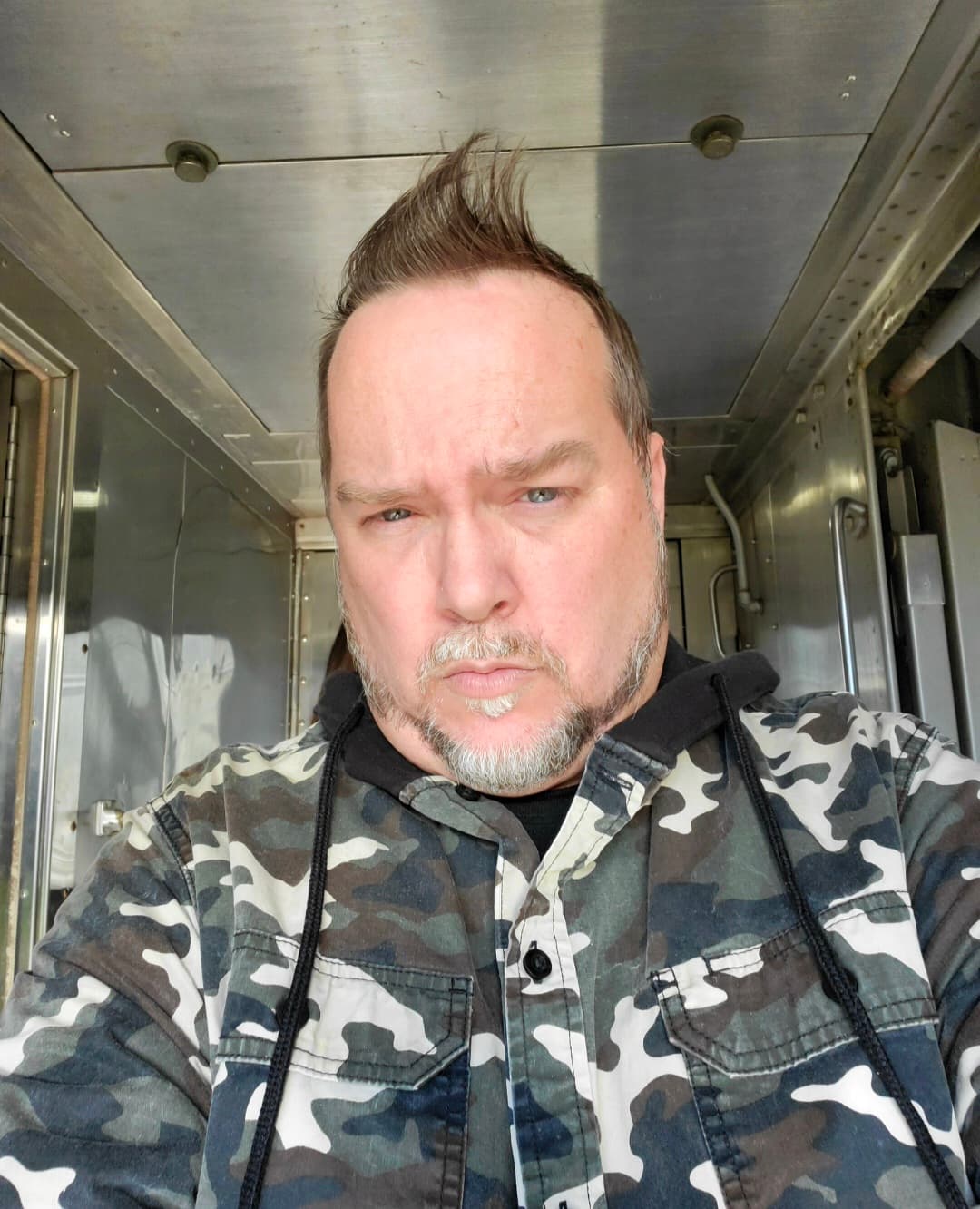 A candid portrait of Kene Bell in a camouflage jacket