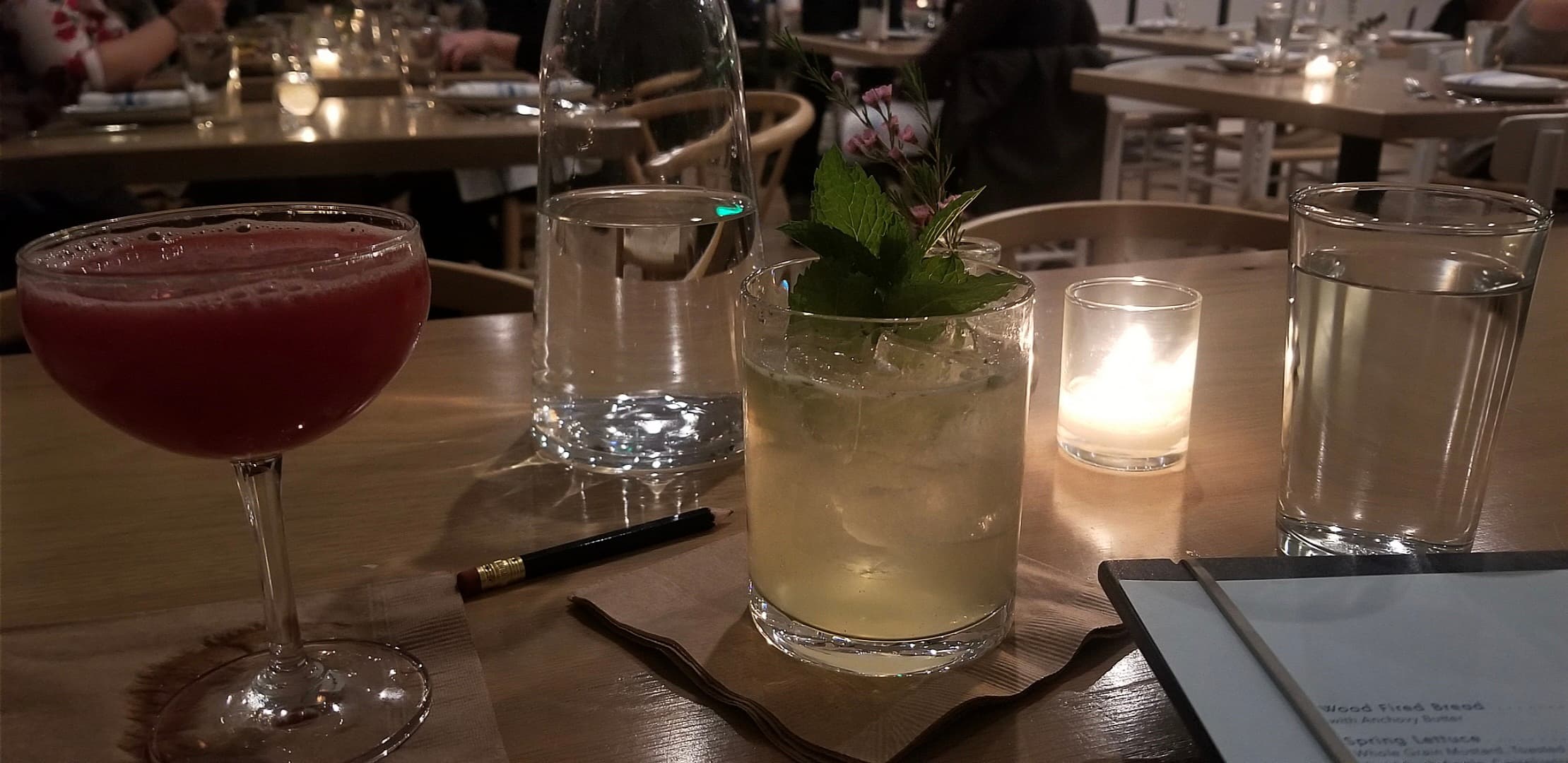 Two cocktails and water glasses on a restaurant table