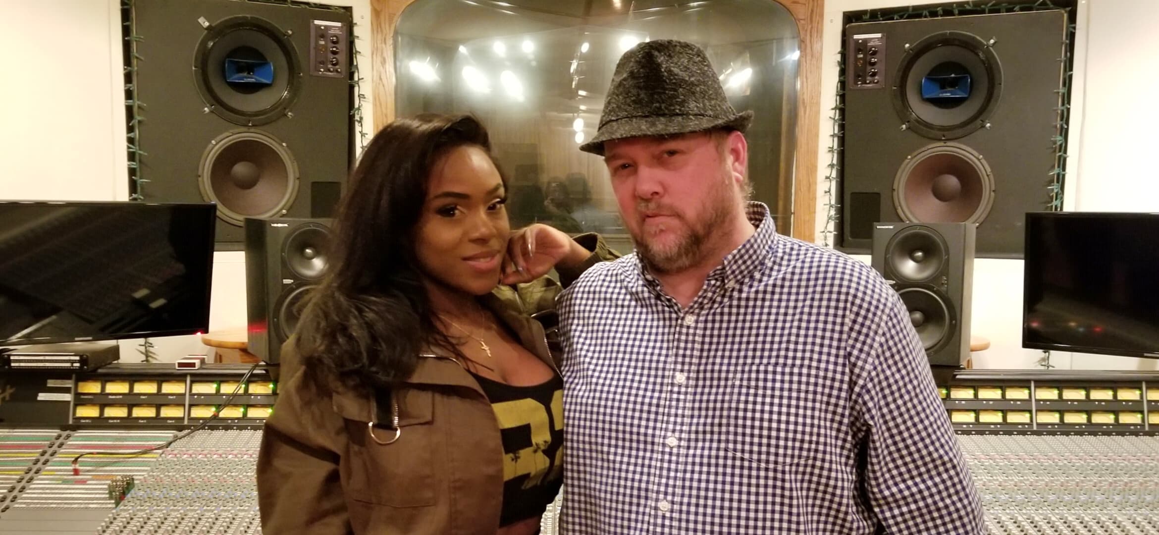 Kene Bell and a collaborator standing before a large recording console