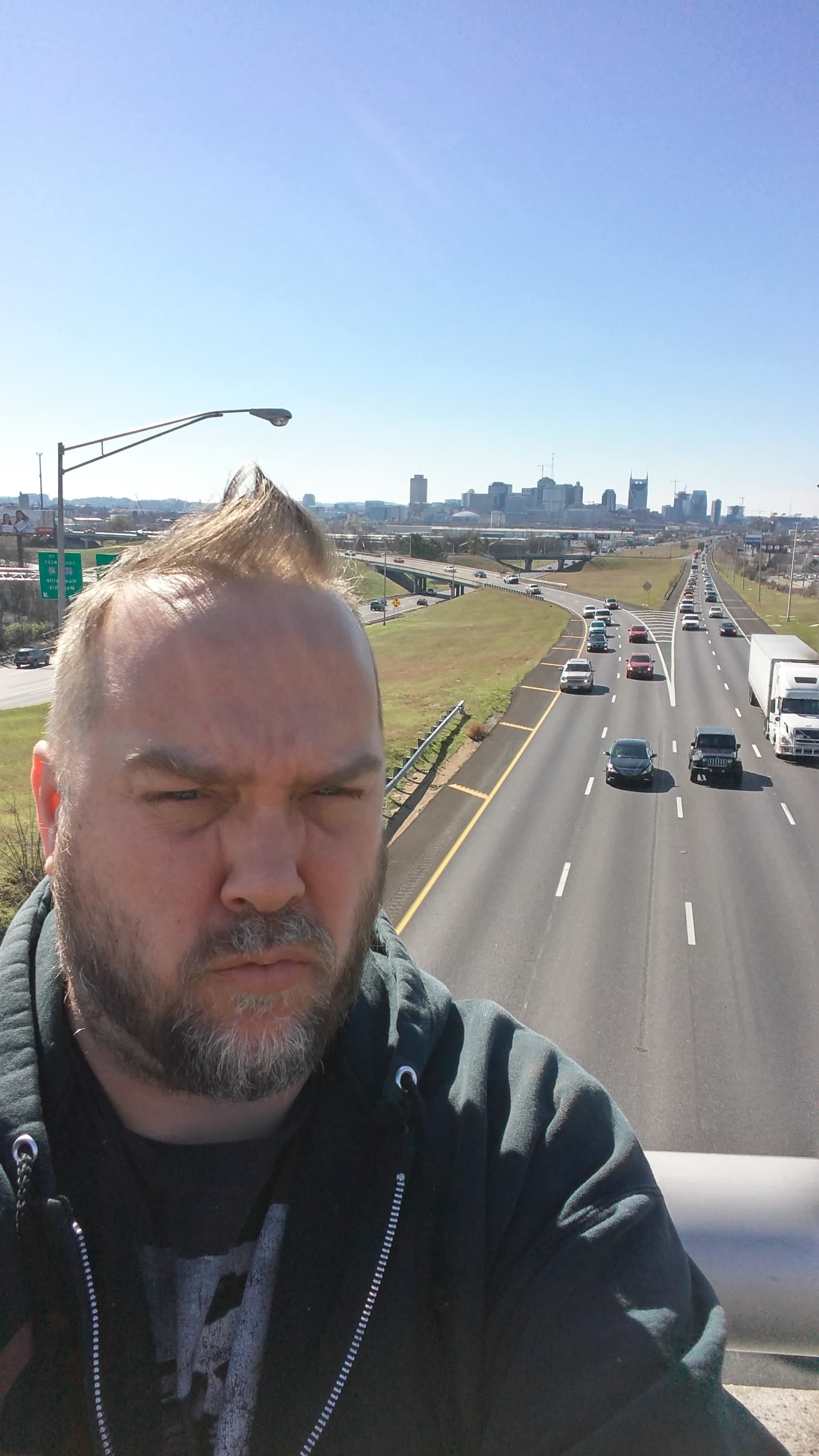 Kene Bell facing the camera with the Nashville skyline and interstate behind him