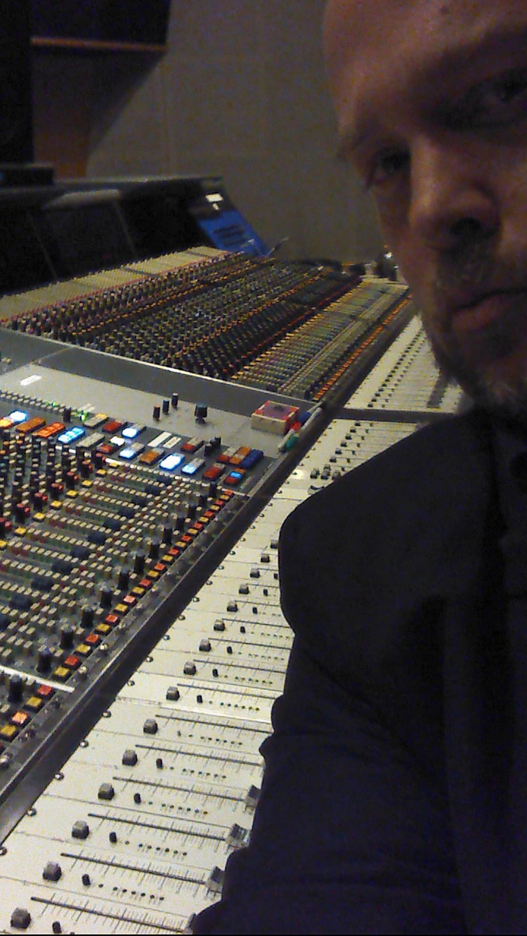 Kene Bell beside a large studio mixing console