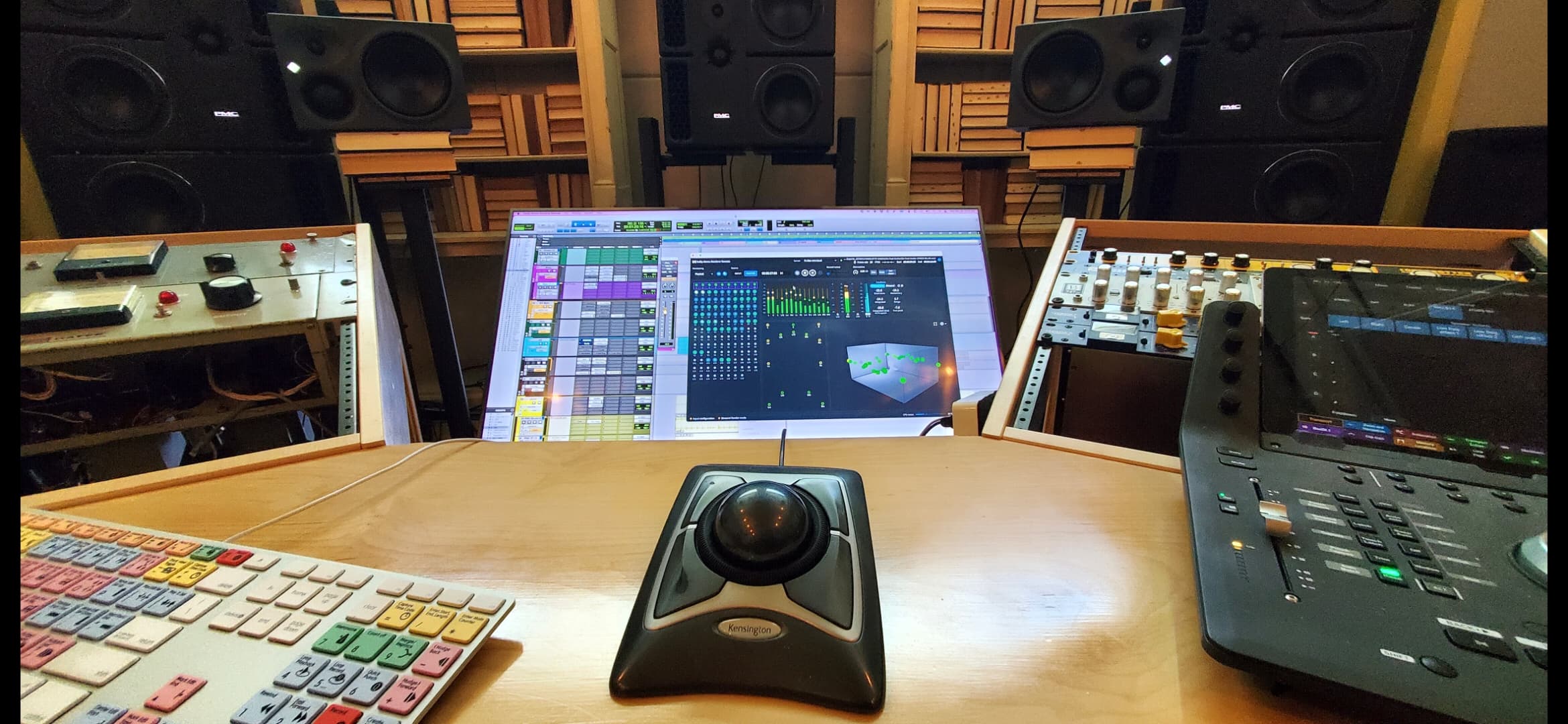 Operator's view across a professional mixing workstation and monitor system