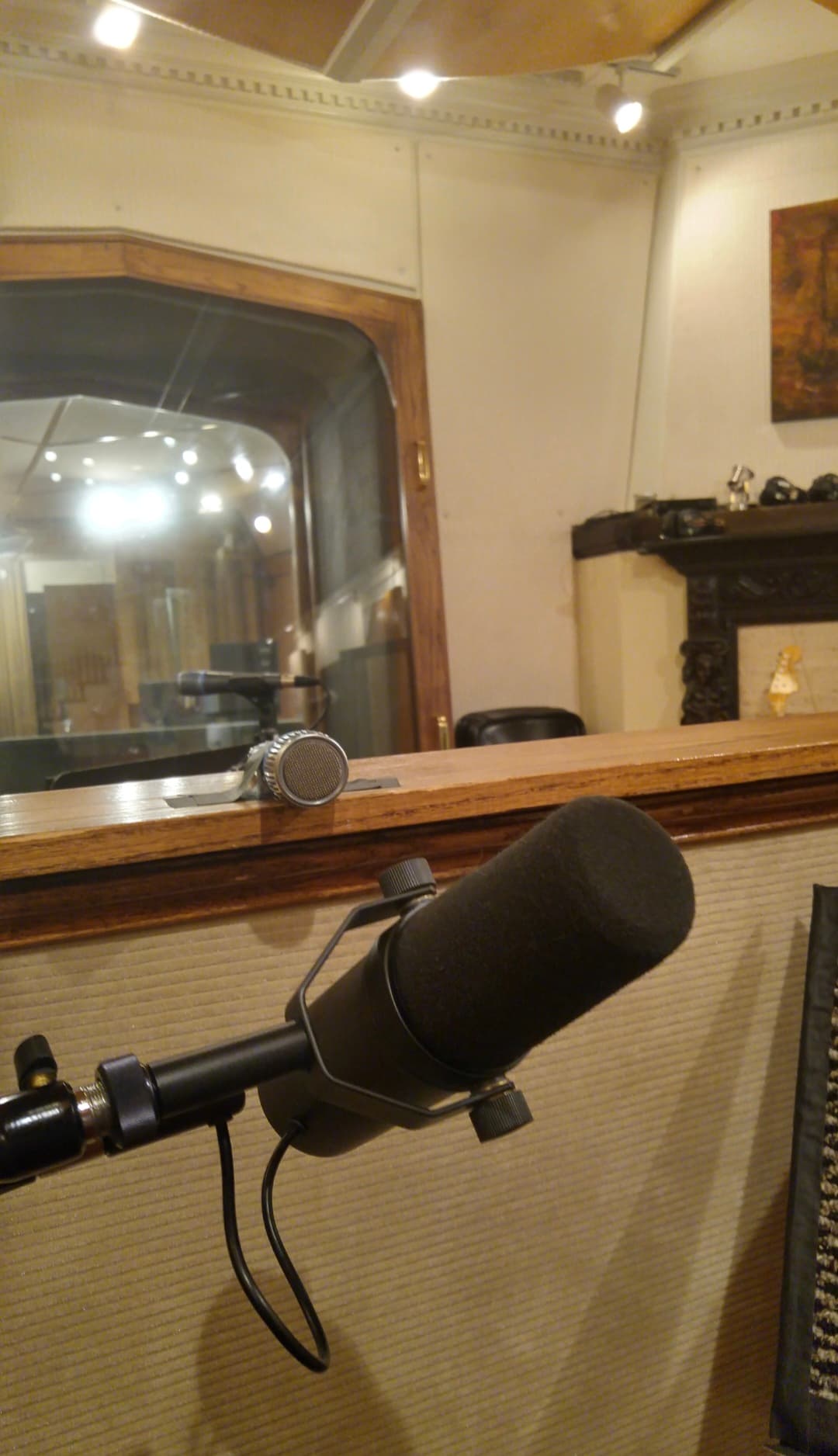 Studio microphone positioned in front of a tracking-room window