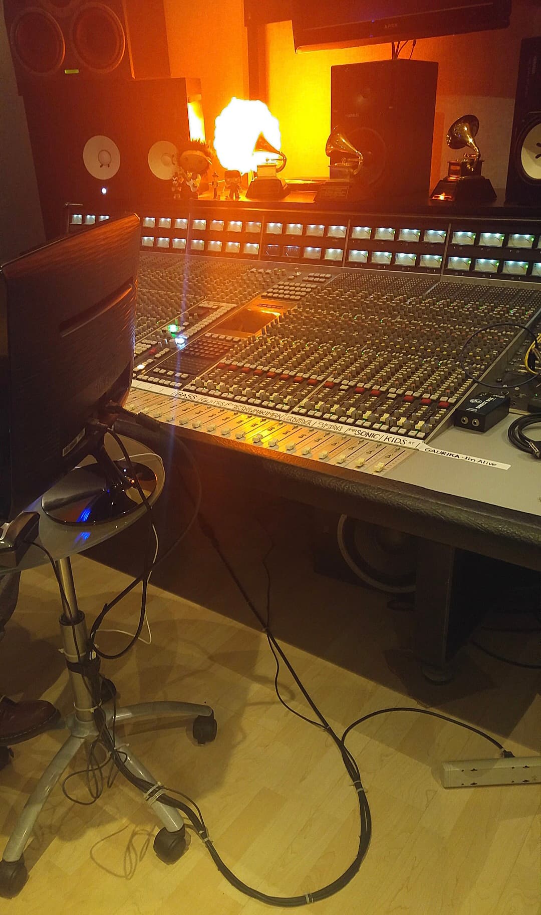 Warm-lit professional control room with a large-format console and monitoring system