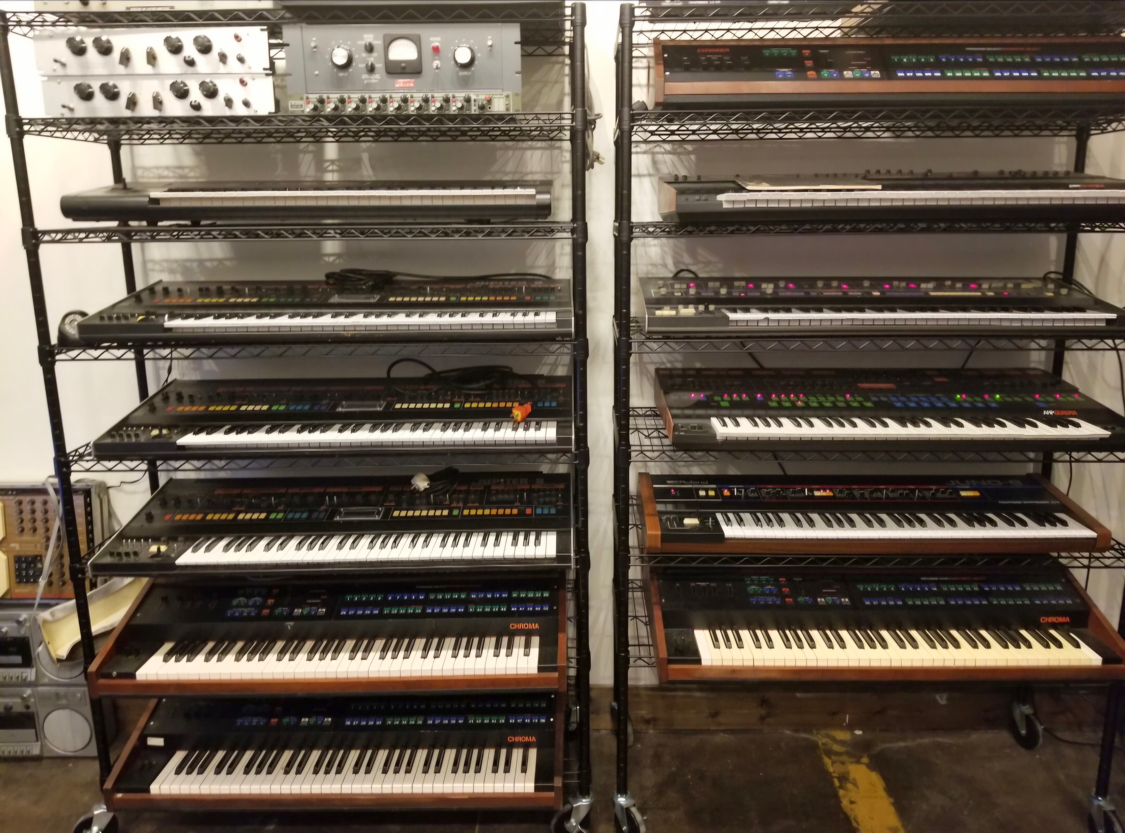 Large collection of keyboards and synthesizers arranged across two racks