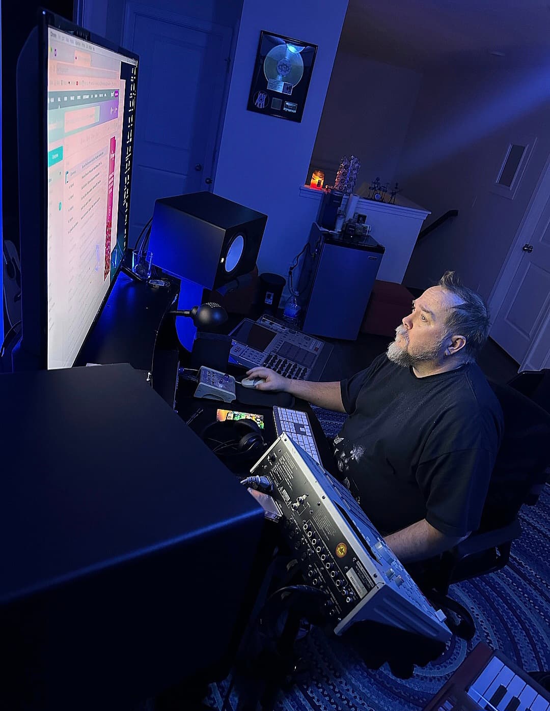 Alternate working angle across a blue-lit Ghostown workstation and monitoring environment