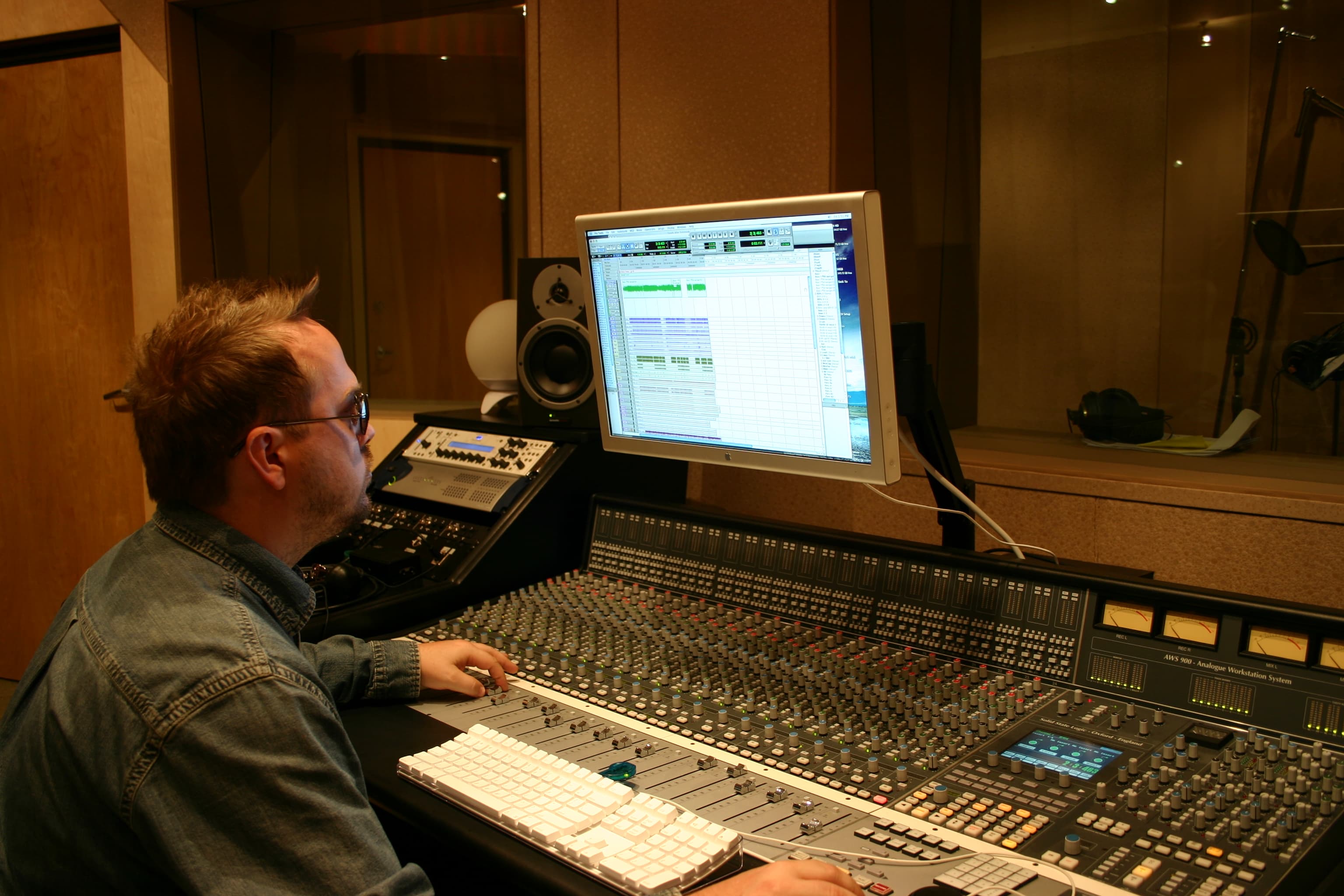 Engineer working at a professional control-room console and digital session