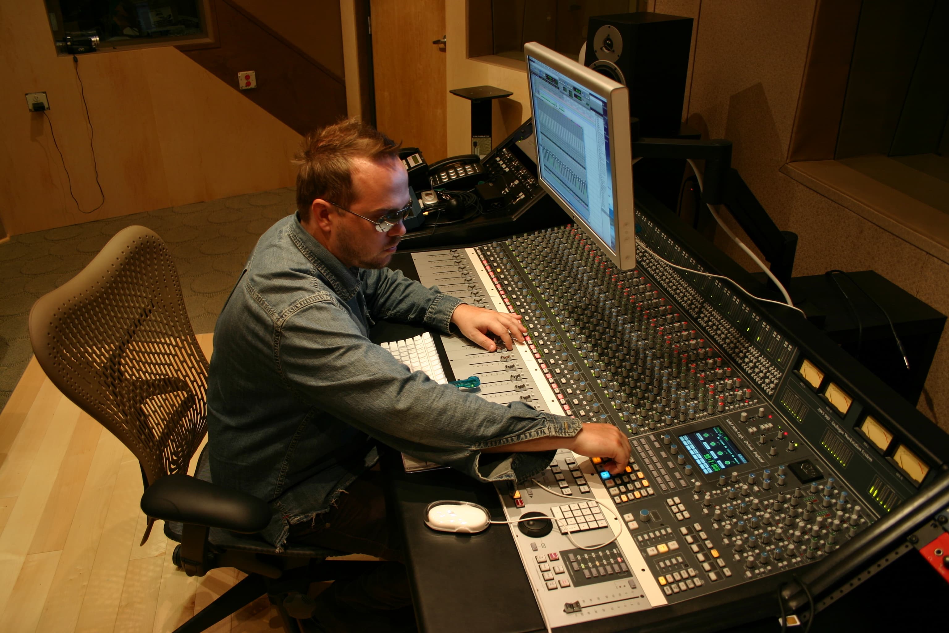Alternate view of an engineer actively adjusting a professional control-room console
