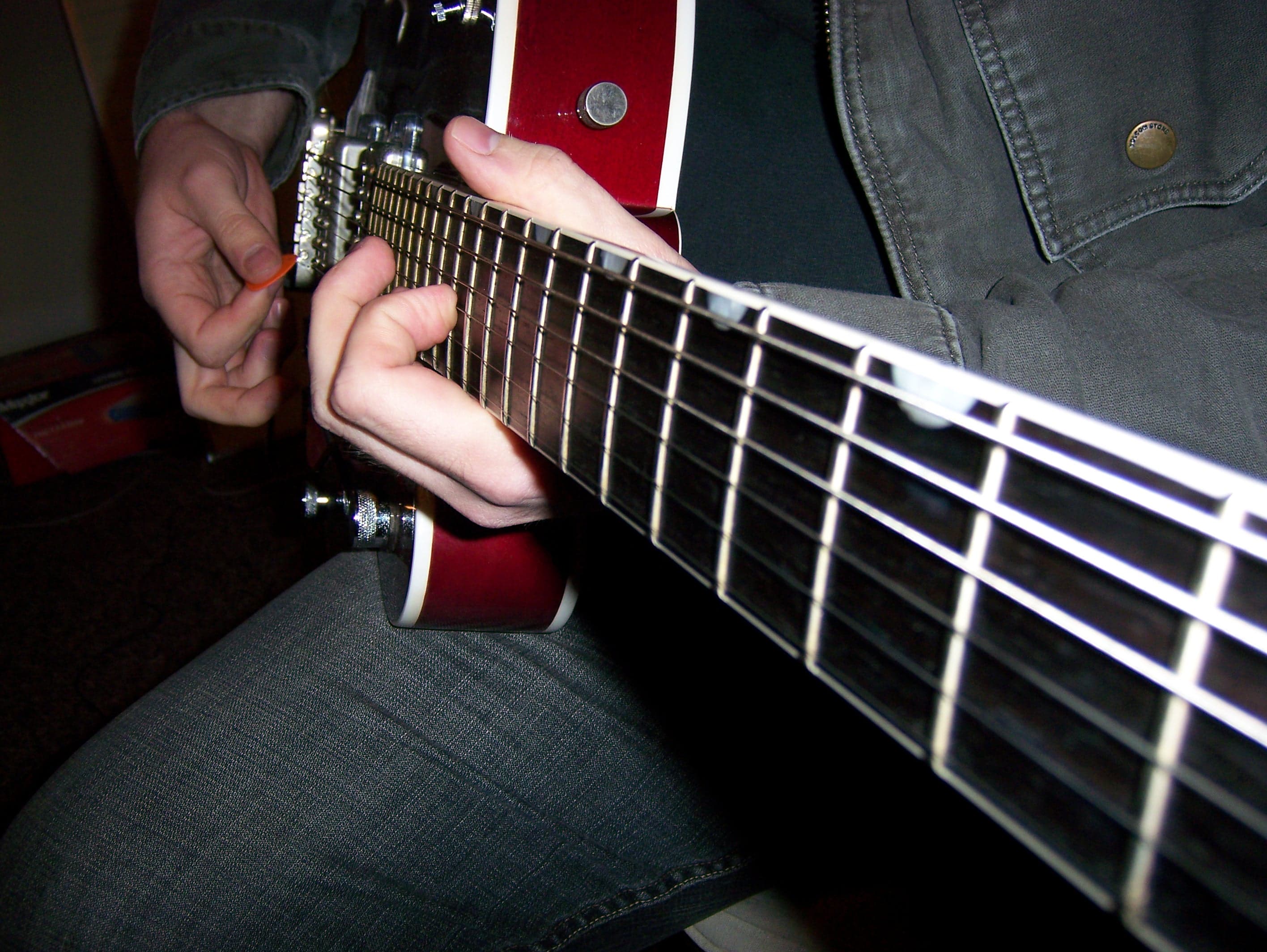 Close view of a musician's hands playing electric guitar