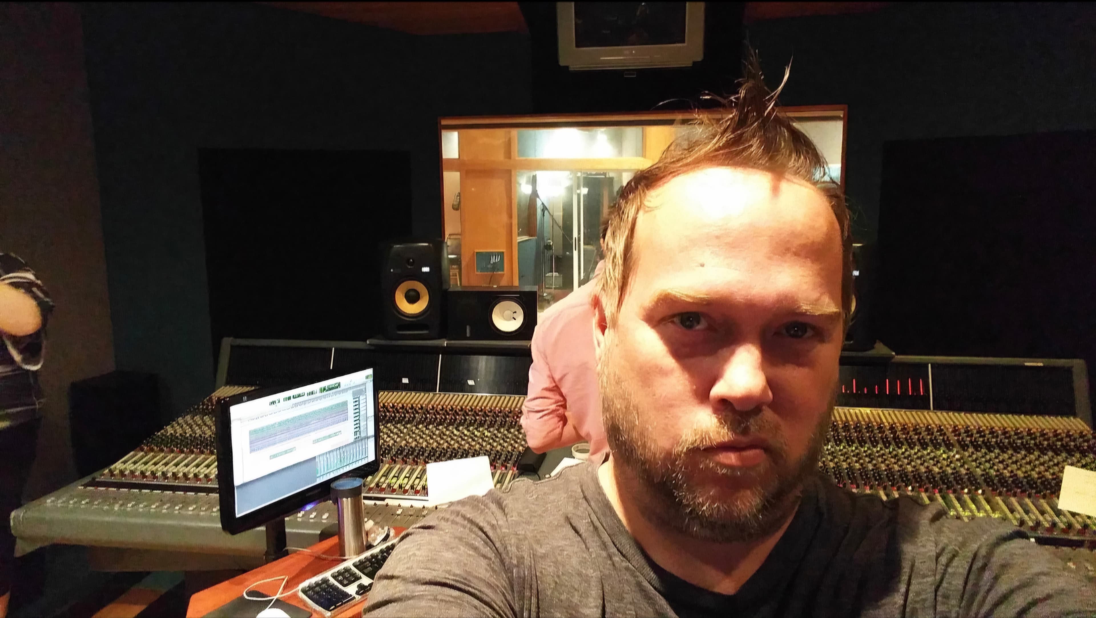 Kene Bell in a professional control room with a large analog console
