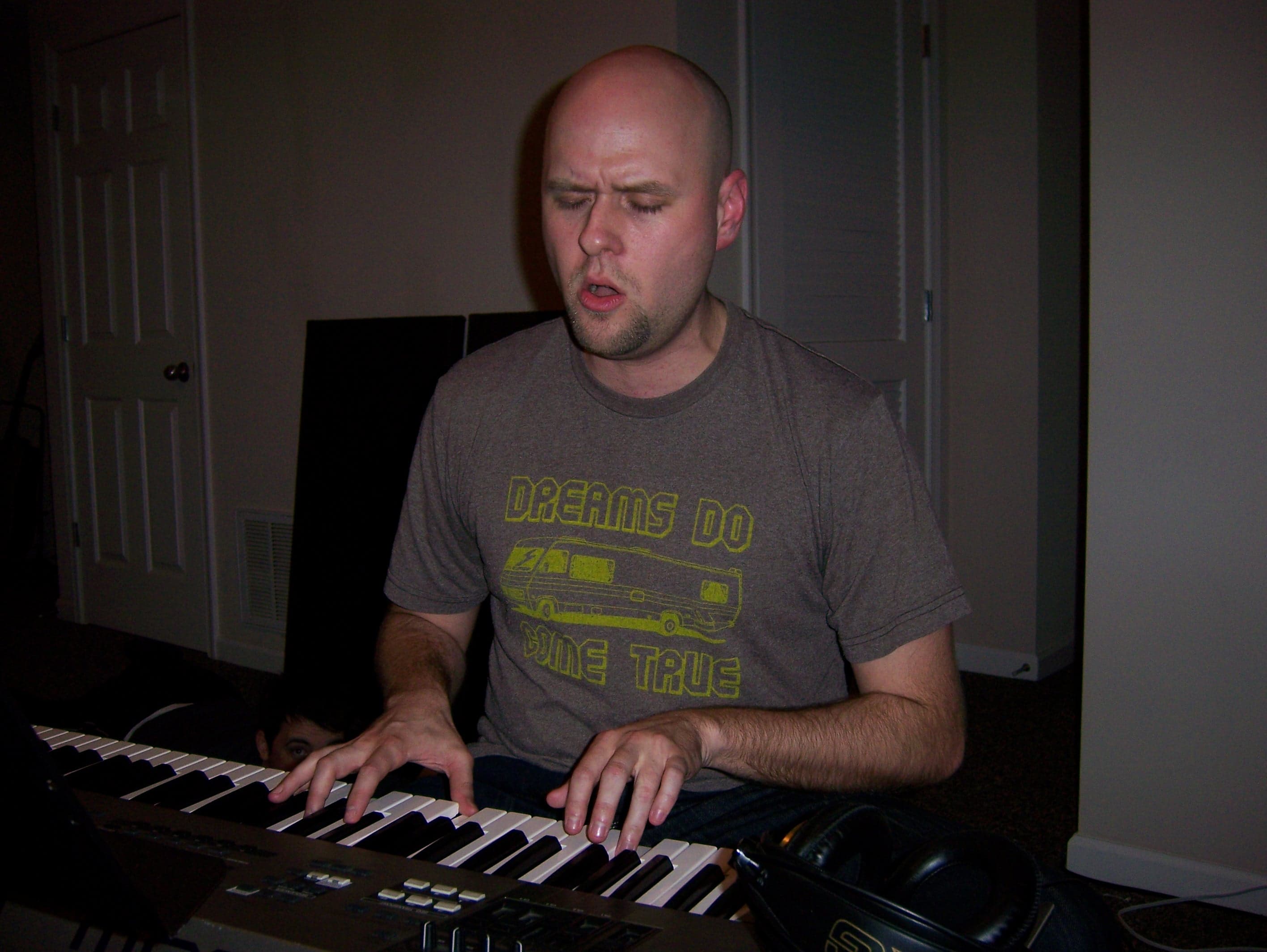 Unidentified musician playing keyboard and singing during a studio session
