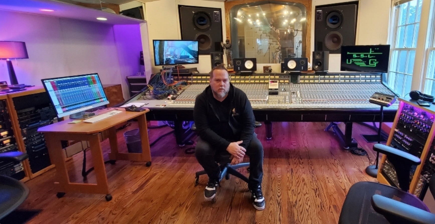 Kene Bell seated at the center of a professional recording studio